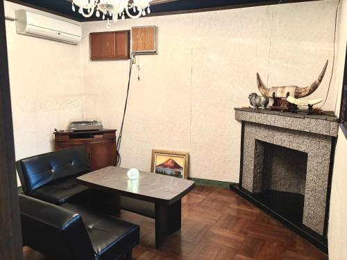a living room with a table and a fireplace at The Grand Stay Shin-Osaka in Osaka