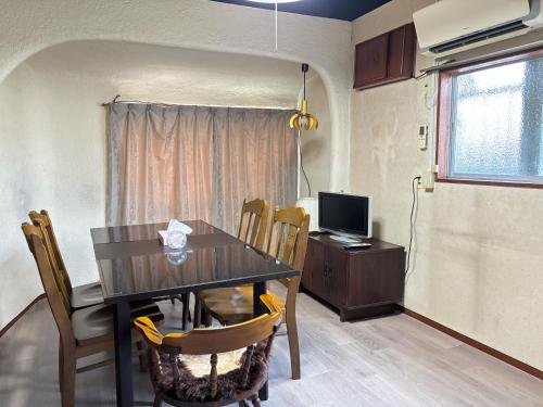 a dining room with a table and a television at The Grand Stay Shin-Osaka in Osaka