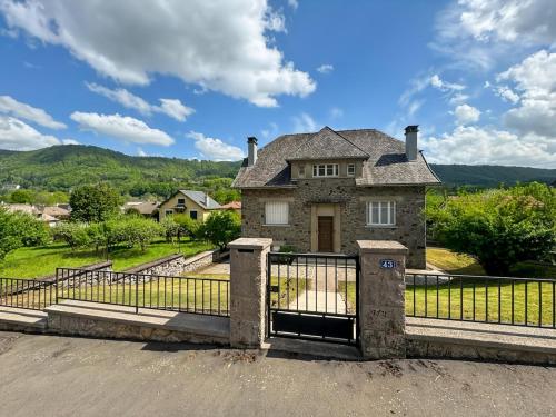 an old house with a gate in front of it at La maison des Hortensias Vic-Sur-Cère, 10 pers in Vic-sur-Cère