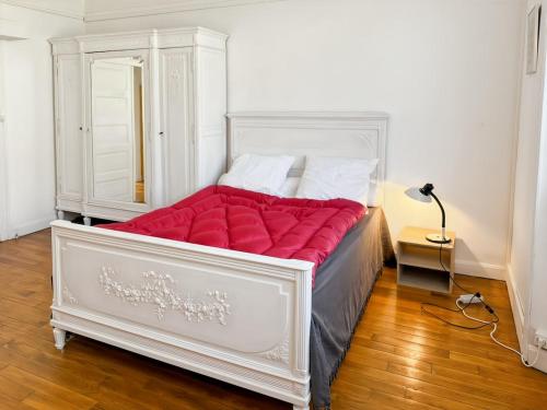 a bedroom with a large bed with a red blanket at La maison des Hortensias Vic-Sur-Cère, 10 pers in Vic-sur-Cère