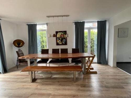 a dining room with a wooden table and chairs at Urban house for families and Berlin tourists in Teltow