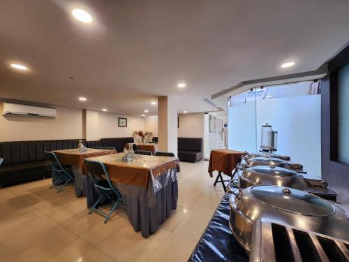 a restaurant with tables and chairs in a room at Hotel Lee International in Kolkata