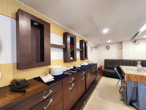 a restaurant with a counter with dishes on it at Hotel Lee International in Kolkata