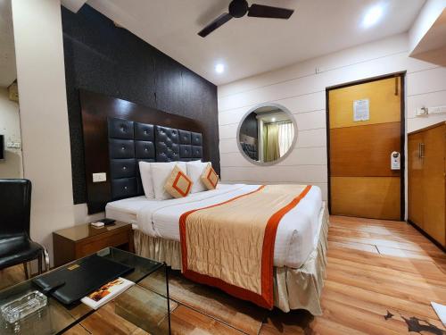 a bedroom with a bed and a table and a mirror at Hotel Lee International in Kolkata