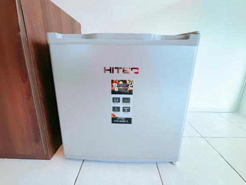 a white refrigerator sitting on the floor in a kitchen at Pangkor Island Pool View Studio 2 Queen Beds 2 Min Walk to the Beach Free WiFi & Parking in Pangkor