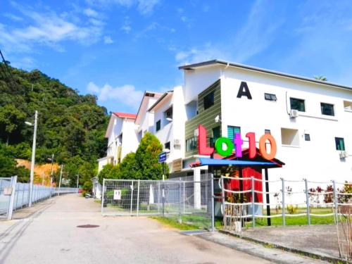 a white building with a sign in front of it at Pangkor Island Pool View Studio 2 Queen Beds 2 Min Walk to the Beach Free WiFi & Parking in Pangkor