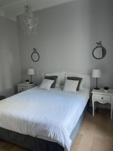 une chambre avec un grand lit blanc avec deux tables de nuit dans l'établissement Appartement 4 étoiles dans propriété classée, à Capbreton