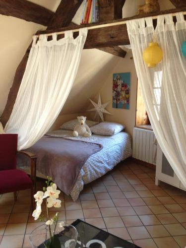 une chambre avec un lit avec un ours en peluche dessus dans l'établissement Charmant pied à terre centre ville, à Dijon