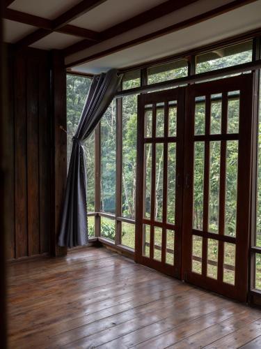 an empty room with large glass doors and windows at Give Garden Eco ສວນສາຍທານ in Paksong