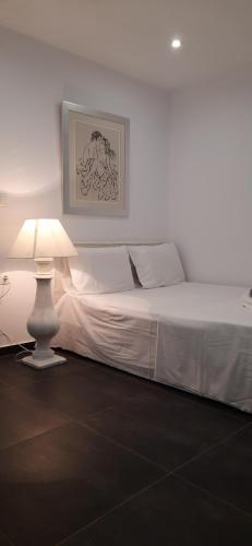 a white bed with a lamp in a room at Central Skyros Hideaway in Skiros