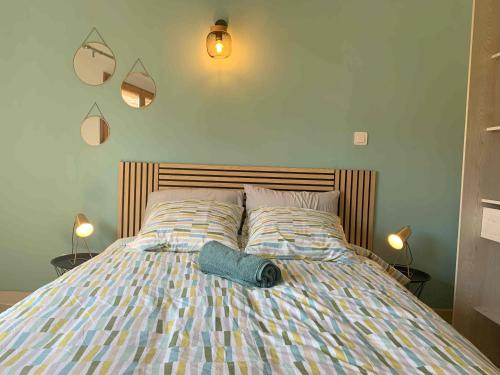 - un lit avec une couette bleue et 2 lampes dans l'établissement CosyCarmes, à Avignon