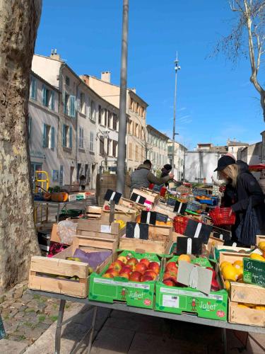 une table remplie de caisses de fruits dans une rue dans l'établissement CosyCarmes, à Avignon