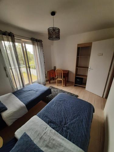 - une chambre avec 2 lits et une table avec une fenêtre dans l'établissement Océan, à Les Sables-dʼOlonne