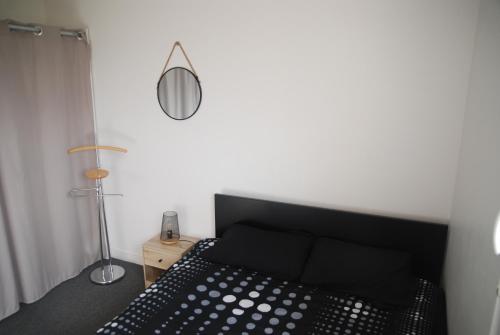 a bedroom with a black bed and a lamp at Mer et calme in Frehel