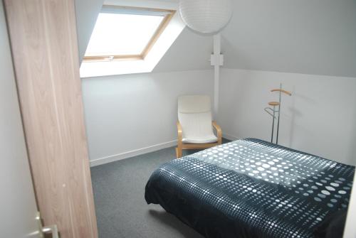 a bedroom with a bed and a window and a chair at Mer et calme in Frehel