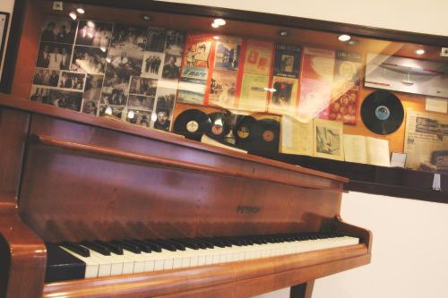 a piano on a shelf with photos and records at Hotel Luna Rossa in Naples