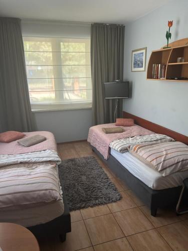 two twin beds in a room with a window at Marta in Okuninka