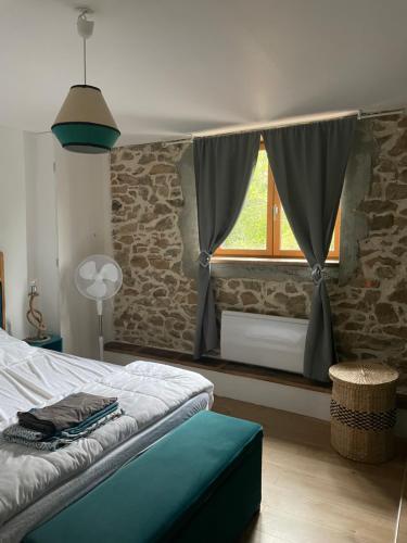une chambre avec un lit et une fenêtre dans l'établissement Grande maison conviviale, à Neuvic-Entier