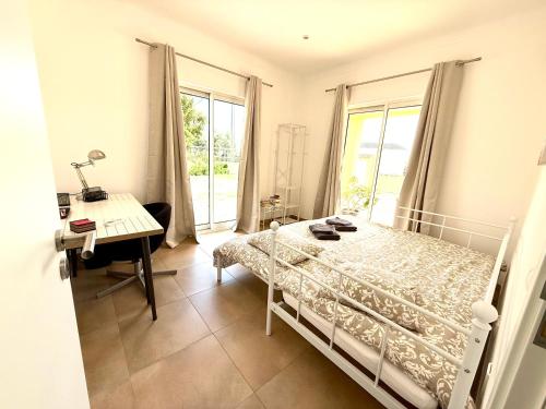 a bedroom with a bed and a desk and a desk at Pôr-do-sol Villa in São Pedro do Corval