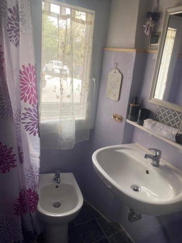 a bathroom with a sink and a toilet and a window at Casa Belvedere in Suvereto