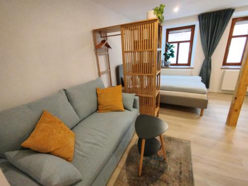 a living room with a blue couch with orange pillows at Angernest, Ferienwohnung in Kamenz in Kamenz