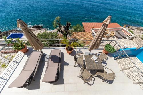 a patio with a table and chairs and the ocean at Vila Dora in Dobra Voda