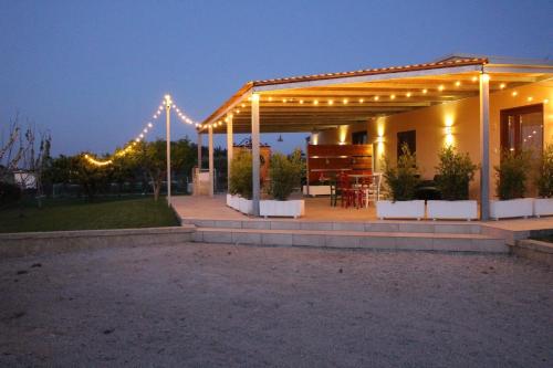 a house with a pergola with lights on it at le casette in Aradeo