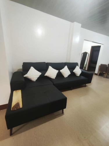 a black couch with pillows in a living room at KBC ZAI Baguio Staycations 3 & 4 in Baguio
