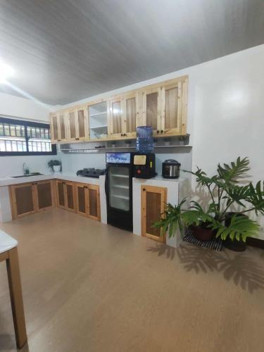 a kitchen with wooden cabinets and a black appliances at KBC ZAI Baguio Staycations 3 & 4 in Baguio