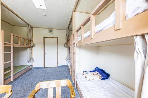 a room with bunk beds and a table and chairs at Guesthouse Sunaen - Vacation STAY 49064v in Tottori