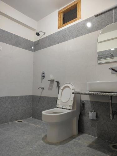 a bathroom with a toilet and a sink at Sun Beam Hotel Koksar in Khoksar