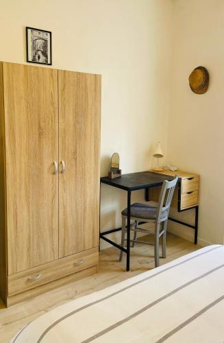 Cette chambre comprend un bureau, une table et un placard. dans l'établissement Le cocon familial, à Digne-Les-Bains