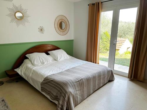 une chambre avec un lit et une grande fenêtre dans l'établissement Domaine Le Font Figuière, à Grasse
