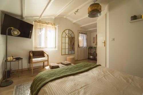 une chambre avec un lit et une chaise dedans dans l'établissement La Cabane de L'Olivier - Suite cosy avec jacuzzi & home cinéma, à Arles