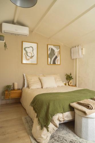 une chambre avec un grand lit avec une couverture verte dans l'établissement La Cabane de L'Olivier - Suite cosy avec jacuzzi & home cinéma, à Arles