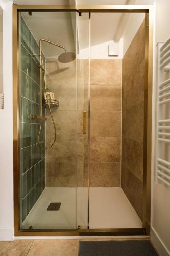 une douche avec une porte vitrée dans une salle de bain dans l'établissement La Cabane de L'Olivier - Suite cosy avec jacuzzi & home cinéma, à Arles