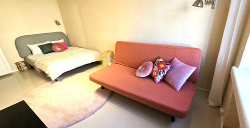 a room with a red chair with pillows on it at Sadama Holiday Apartment in Kõrgessaare