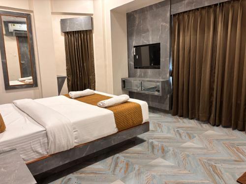 a bedroom with two beds and a flat screen tv at hotel Arts palace in Mumbai
