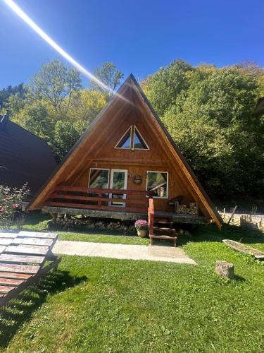 a small cabin with a thatched roof at Cabanutze Satic in Rucăr