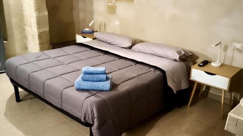 a bedroom with a large bed with blue towels on it at I Tre Pumi in Surbo