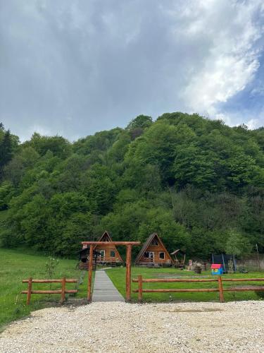 a barn with a wooden fence in front of a mountain at Cabanutze Satic in Rucăr