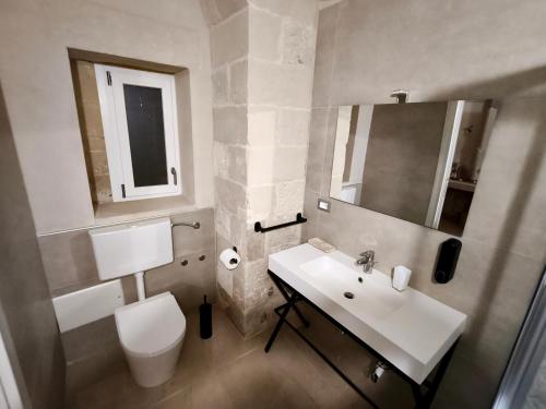 a bathroom with a white toilet and a sink at I Tre Pumi in Surbo