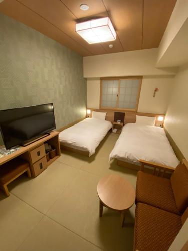 a room with two beds and a flat screen tv at Onyado Nono Nara Natural Hot Spring in Nara