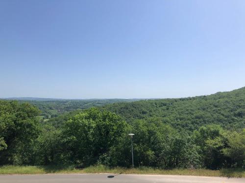 a view of a mountain with a street light and trees at Gîte du Causse in Boussac