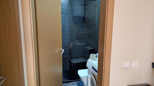a bathroom with a toilet and a sink at Cozy apartment in Prishtinë