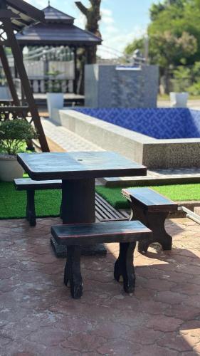 a picnic table and two benches in a park at D'BALI HOMESTAY - Private Swimming Pool, NETFLIX, Internet Wifi ,Cuckoo, Internet Wifi , Dryer, Washing Machine, Aircond Setiap Bilik & Ruang Tamu in Pasir Puteh