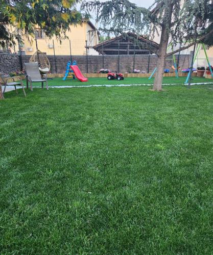 a park with a playground with a tree in the grass at Garden's House Pozar in Aridaia in Aridaia