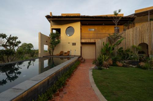 a house with a swimming pool next to a house at Chuồn Chuồn Retreat in Phan Thiet