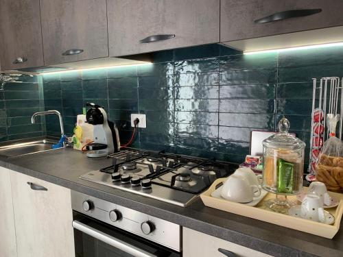 a kitchen counter with a stove and a sink at Casa Virgilio in Venosa