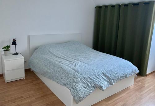 - une chambre avec un lit et un rideau vert dans l'établissement Charment Appartement Duplex - Pornichet, à Pornichet